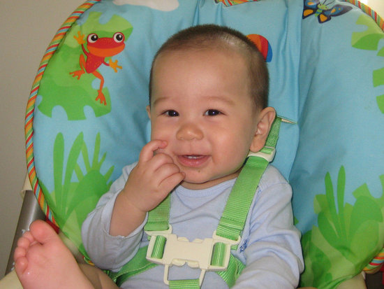 Showing off in his high chair. Showing off in his high chair.
